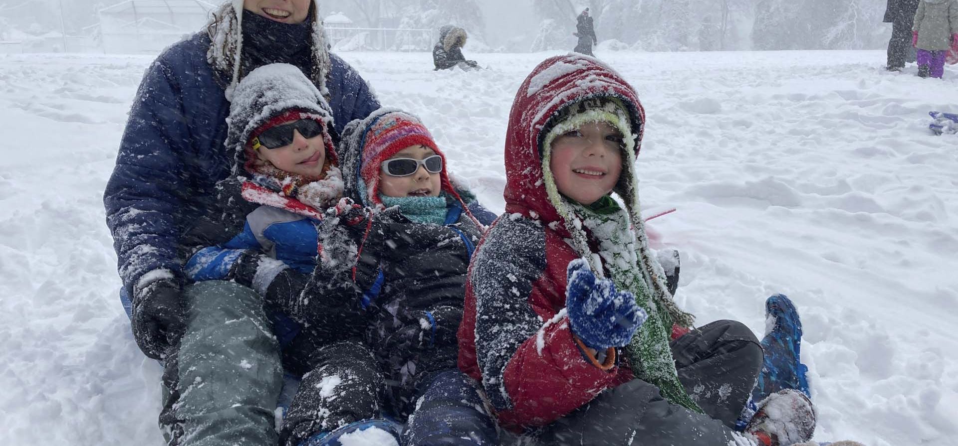 Una madre con sus hijos se preparan para descender la gran colina detrás de la escuela primaria Lemon Road durante una tormenta de nieve en Falls Church, Virginia. Una fuerte tormenta invernal la nieve entró en la capital de la nación el lunes, cerró oficinas gubernamentales y escuelas y dejó en tierra el helicóptero del presidente.