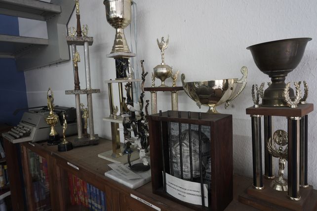 Los libros sobre la temática del ajedrez facilitaron a muchos jugadores conseguir títulos y trofeos importantes que se exhiben en la biblioteca.