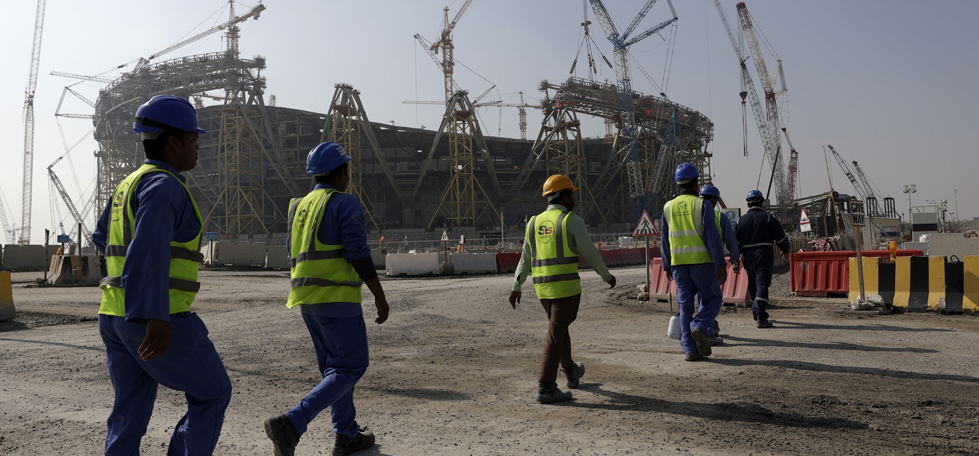 Trabajadores caminan hacia el estadio de Lusail, uno de los estadios de la Copa del Mundo de 2022, en Lusail, Qatar, el 20 de diciembre de 2019. Un ex oficial de la CIA que espió a los rivales de Qatar para ayudar al pequeño país árabe a ganar la Copa del Mundo de este año ahora está bajo el control del FBI. El escrutinio y los documentos recién obtenidos muestran que ofreció servicios clandestinos que iban más allá del fútbol para tratar de influir en la política estadounidense.