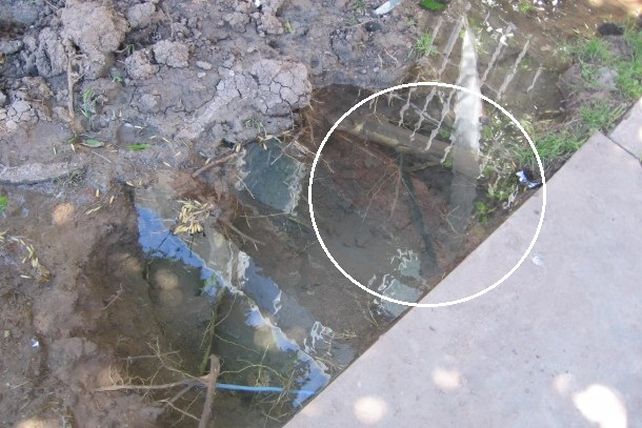 Vecinos preocupados por un pozo inundado y por el que pasan cables de la luz