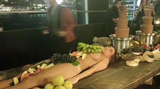 Un bar usa mujeres desnudas como bandejas para servir frutas