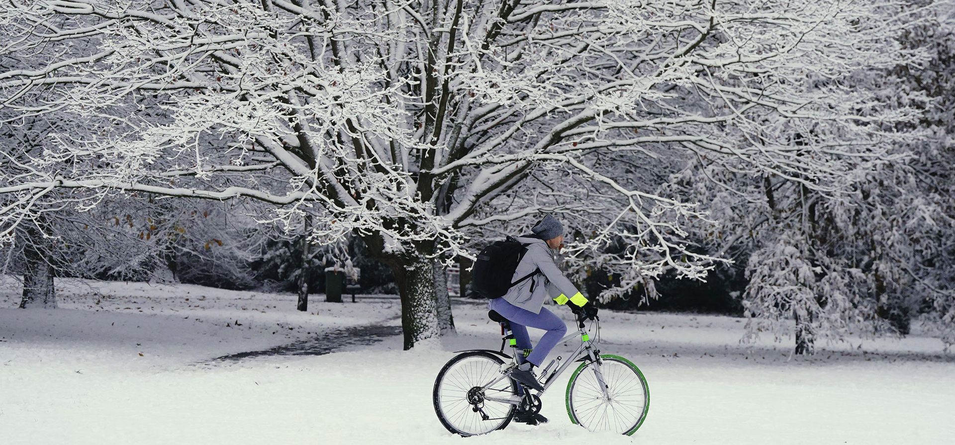 Una persona anda en bicicleta a través de la nieve en Greenwich Park, Londres, el lunes 12 de diciembre de 2022. La nieve y el hielo han barrido partes del Reino Unido, con condiciones invernales frías que continuarán durante días.