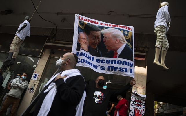 Los propietarios de pequeñas empresas ondean un cartel que muestra al presidente de Estados Unidos