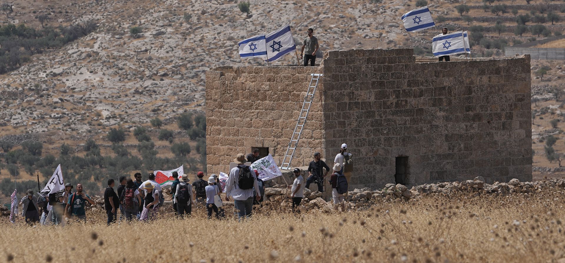 Colonos izaron banderas israelíes en una estructura palestina después de que activistas por la paz israelíes y extranjeros la derribaran durante una protesta en apoyo de los terratenientes locales cuyas propiedades están amenazadas de expropiación por parte de los colonos, en las afueras de la ciudad de Beit Sahour, en Cisjordania, el viernes 14 de agosto de 2026. (Foto AP/Mahmoud Illean) Colonos izaron banderas israelíes en una estructura palestina después de que activistas por la paz israelíes y extranjeros la derribaran durante una protesta en apoyo de los terratenientes locales cuyas propiedades están amenazadas de expropiación por parte de los colonos, en las afueras de la ciudad de Beit Sahour, en Cisjordania, el viernes 14 de agosto de 2026. (Foto AP/Mahmoud Illean)