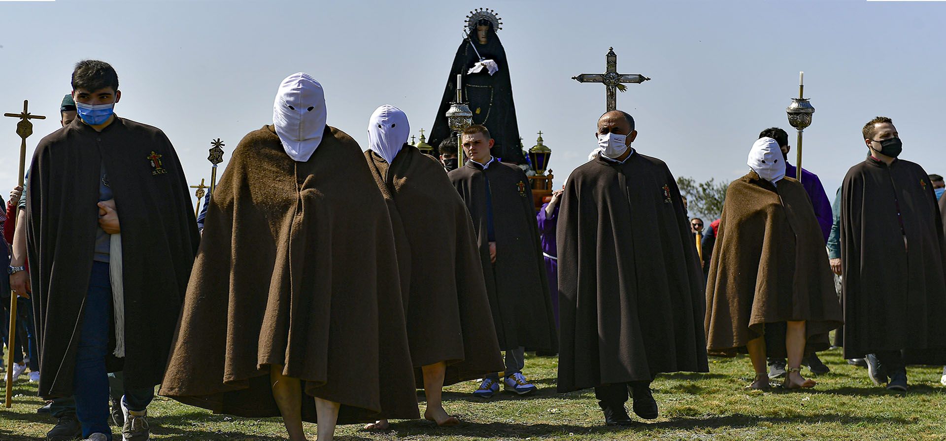 Una hermandad de penitentes encapuchados participa en una procesión de Semana Santa conocida como