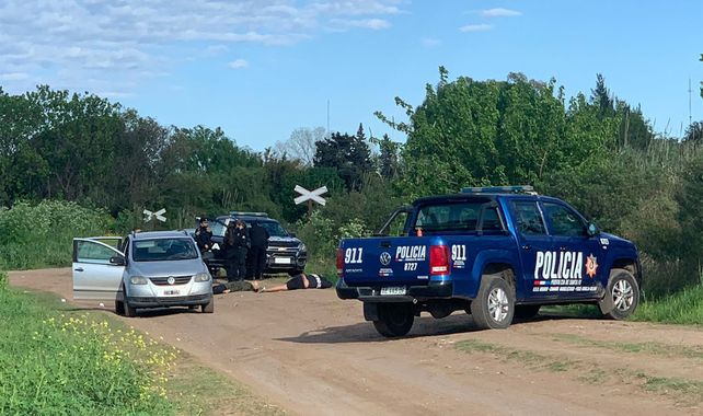 Las víctimas del doble crimen yacen sobre el camino de tierra. Muy cerca