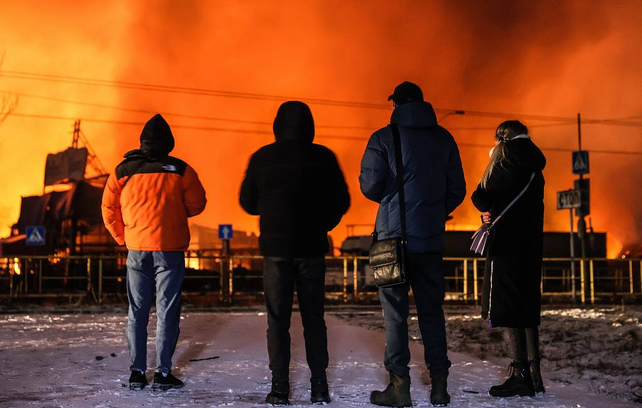 Habitantes de Feodosia se recortan contra las llamas que causó el incendio del buque de la flota rusa. La ciudad es ucraniana pero está ocupada por Rusia desde 2014, como toda Crimea.