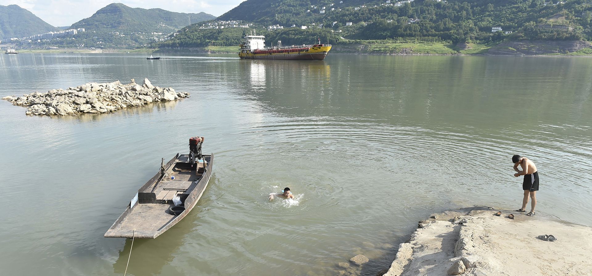 Residentes se refrescan a lo largo del río Yangtze en el condado de Yunyang en la municipalidad de Chongqing, suroeste de China, el martes 16 de agosto de 2022. Las temperaturas inusualmente altas y una sequía prolongada están afectando a grandes franjas de China.