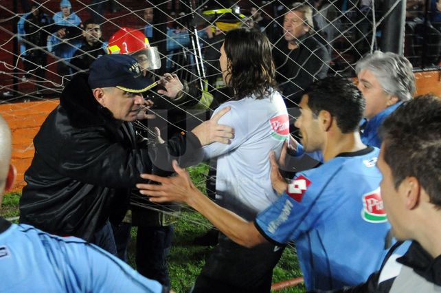 Descontrolado. El arquero Juan Carlos Olave discute con un agente policial y el bombero Santa Cruz (de casco rojo) levanta las manos para defenderse.