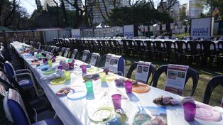 Pedido de liberación. Las mesas y sillas con los rostros de los 242 rehenes se exhiben en el stand de Israel en Colectividades.