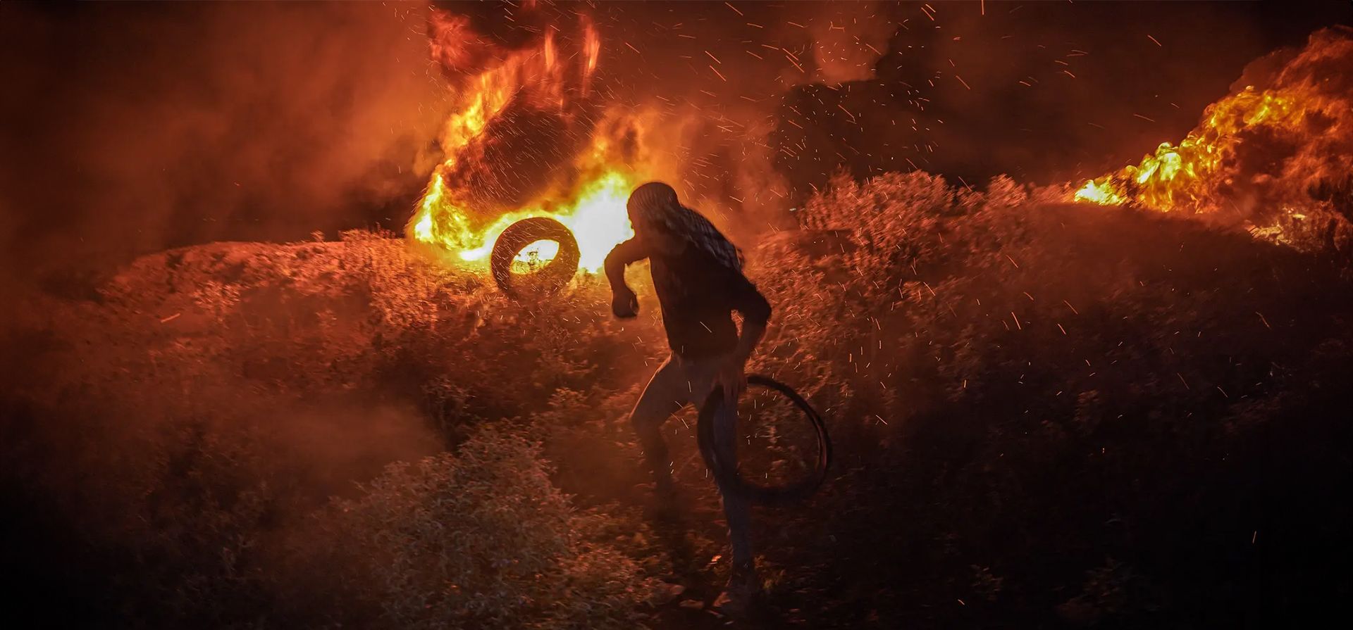 Gaza. Un joven palestino arroja neumáticos de goma sobre un incendio durante una protesta. Fotografía: Saher Alghorra/Zuma Press Wire/Shutterstock Gaza. Un joven palestino arroja neumáticos de goma sobre un incendio durante una protesta. Fotografía: Saher Alghorra/Zuma Press Wire/Shutterstock
