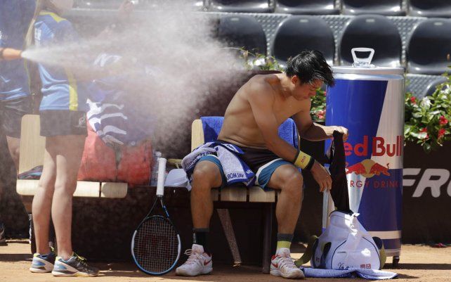 El japonés Kei Nishikori se cambia de camiseta durante el partido contra el italiano Fabio Fognini en el torneo Abierto de tenis de Italia, en Roma.