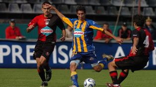 En el Coloso, en 2007. Ángel Di María se prepara para sacar un zurdazo ante el cierre de Araujo y la presión del Colo Ré.
