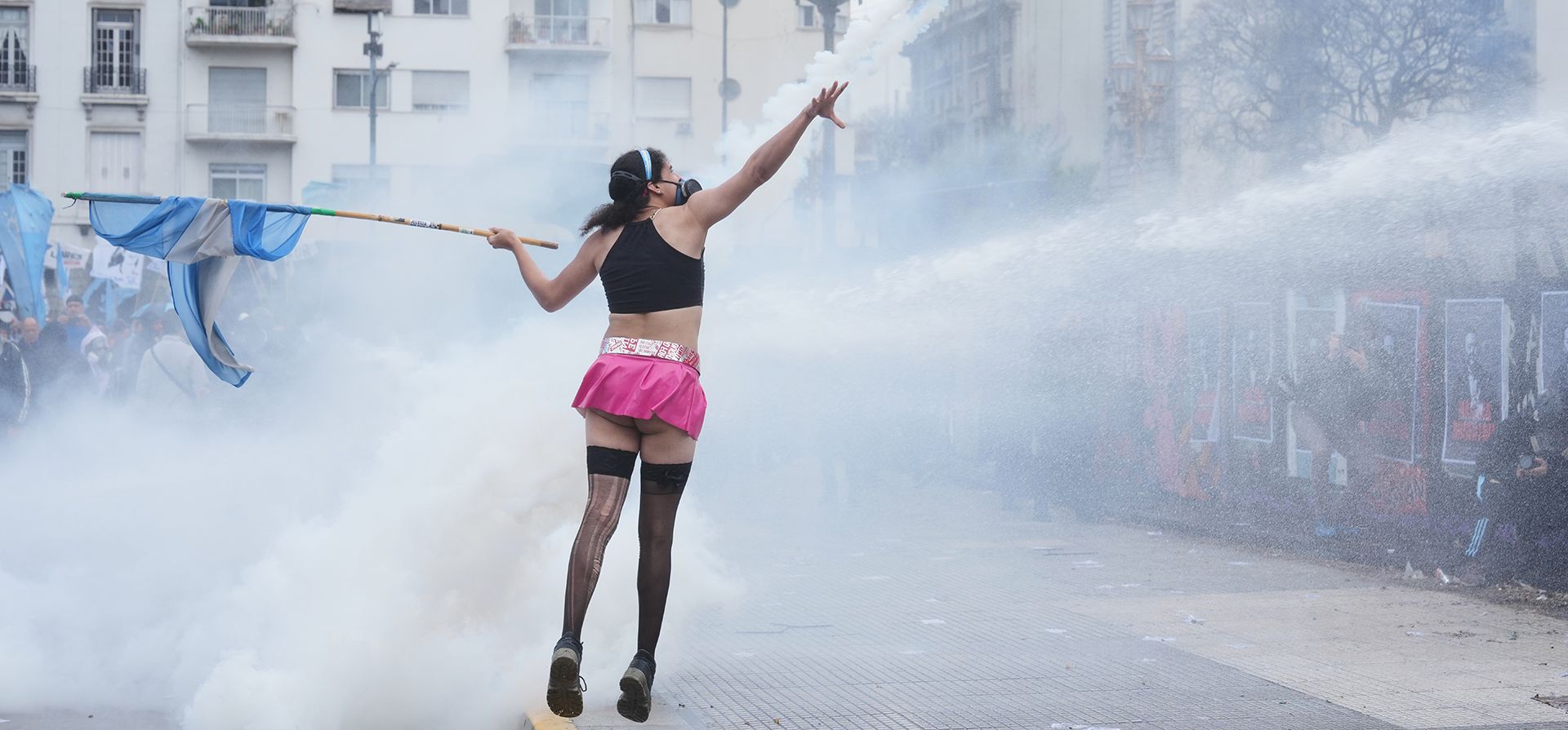 Una manifestante antigubernamental sostiene una bandera argentina mientras la policía utiliza un cañón de agua para dispersar a los manifestantes en Buenos Aires, Argentina, el jueves 15 de octubre de 2026. (Foto AP/Rodrigo Abd) Una manifestante antigubernamental sostiene una bandera argentina mientras la policía utiliza un cañón de agua para dispersar a los manifestantes en Buenos Aires, Argentina, el jueves 15 de octubre de 2026. (Foto AP/Rodrigo Abd)