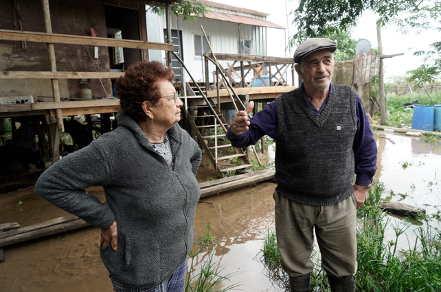 Juana y Beto usan botas de agua para caminar por las afueras de su casa, en el Charigüé.
