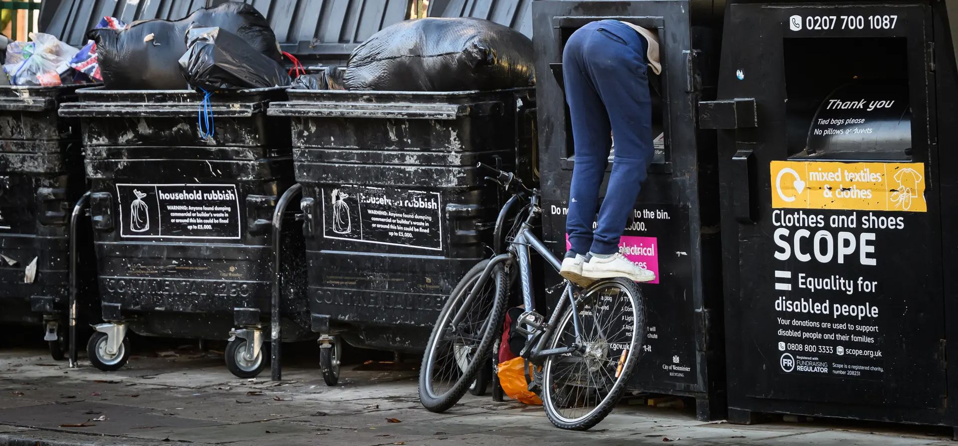 Un hombre se balancea en una bicicleta mientras busca objetos de valor dentro de un contenedor de reciclaje de artículos eléctricos, Londres, Reino Unido. Fotografía: Leon Neal/Getty Images Un hombre se balancea en una bicicleta mientras busca objetos de valor dentro de un contenedor de reciclaje de artículos eléctricos, Londres, Reino Unido. Fotografía: Leon Neal/Getty Images