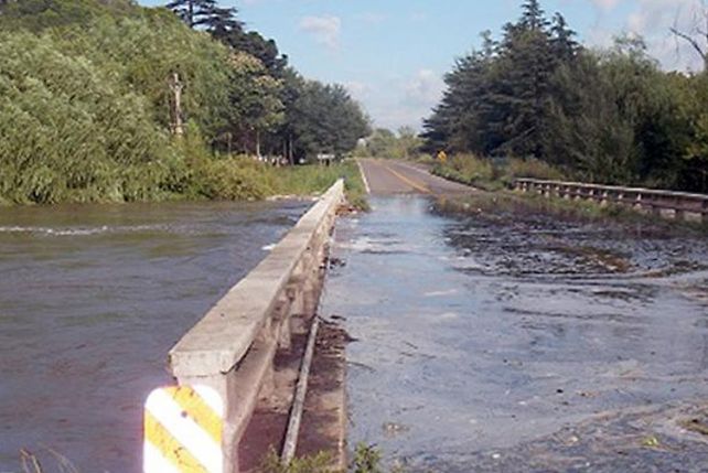 Sobre el asfalto. El río se metió en el puente y recién el lunes Vialidad evaluará el estado de la estructura.