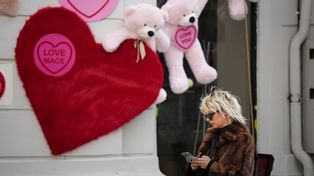 Una mujer revisa su teléfono junto a una tienda decorada con ositos de peluche y recortes en forma de corazón en Bucarest, Rumania, el martes 14 de febrero de 2023. Nunca antes de la caída del gobierno comunista en Rumania en 1989, el Día de San Valentín se volvió cada vez más popular. en los años siguientes y ahora es ampliamente adoptado por los jóvenes rumanos. (Foto AP/Andreea Alexandru)