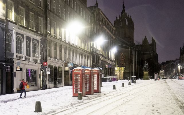 Un hombre toma una foto de la nieve a lo largo de la Royal Mile en Edimburgo. El centro y sureste de Escocia se encuentra amenazado por la tormenta Christoph con pronóstico climáticos desafiantes.