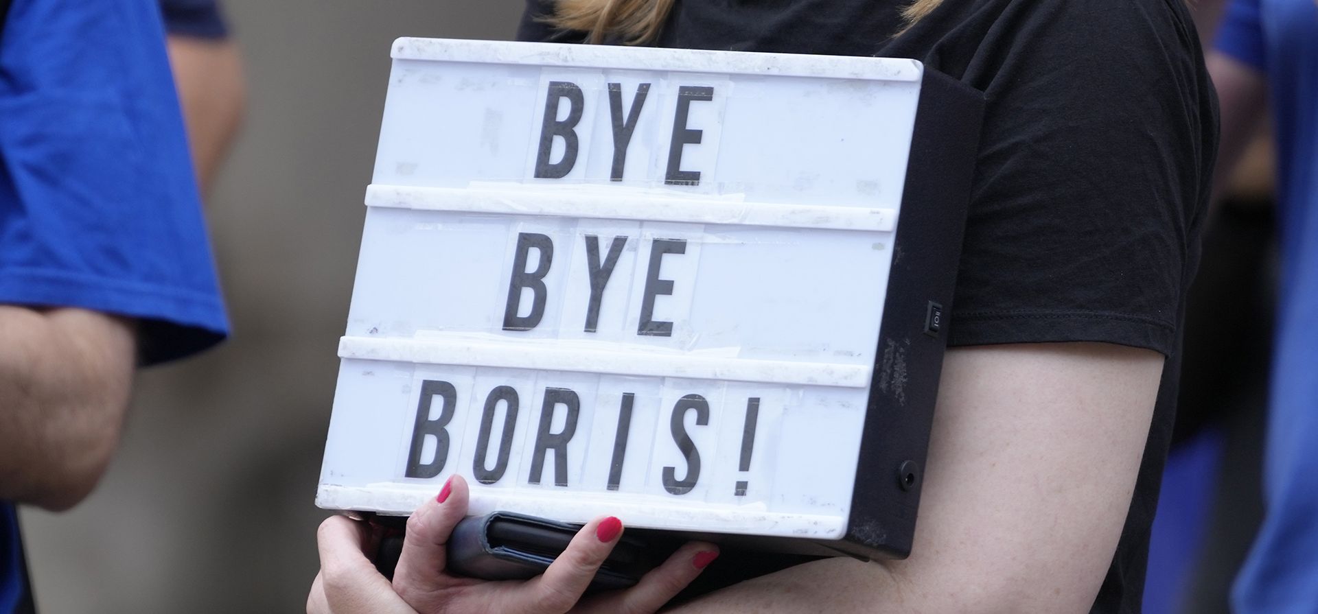 Una mujer sostiene una pancarta durante una manifestación en Westminster, en Londres, el lunes 5 de septiembre de 2022. El gobernante Partido Conservador anunció que la secretaria de Relaciones Exteriores, Liz Truss, obtuvo la mayor cantidad de votos de los miembros del partido para suceder a Boris Johnson.