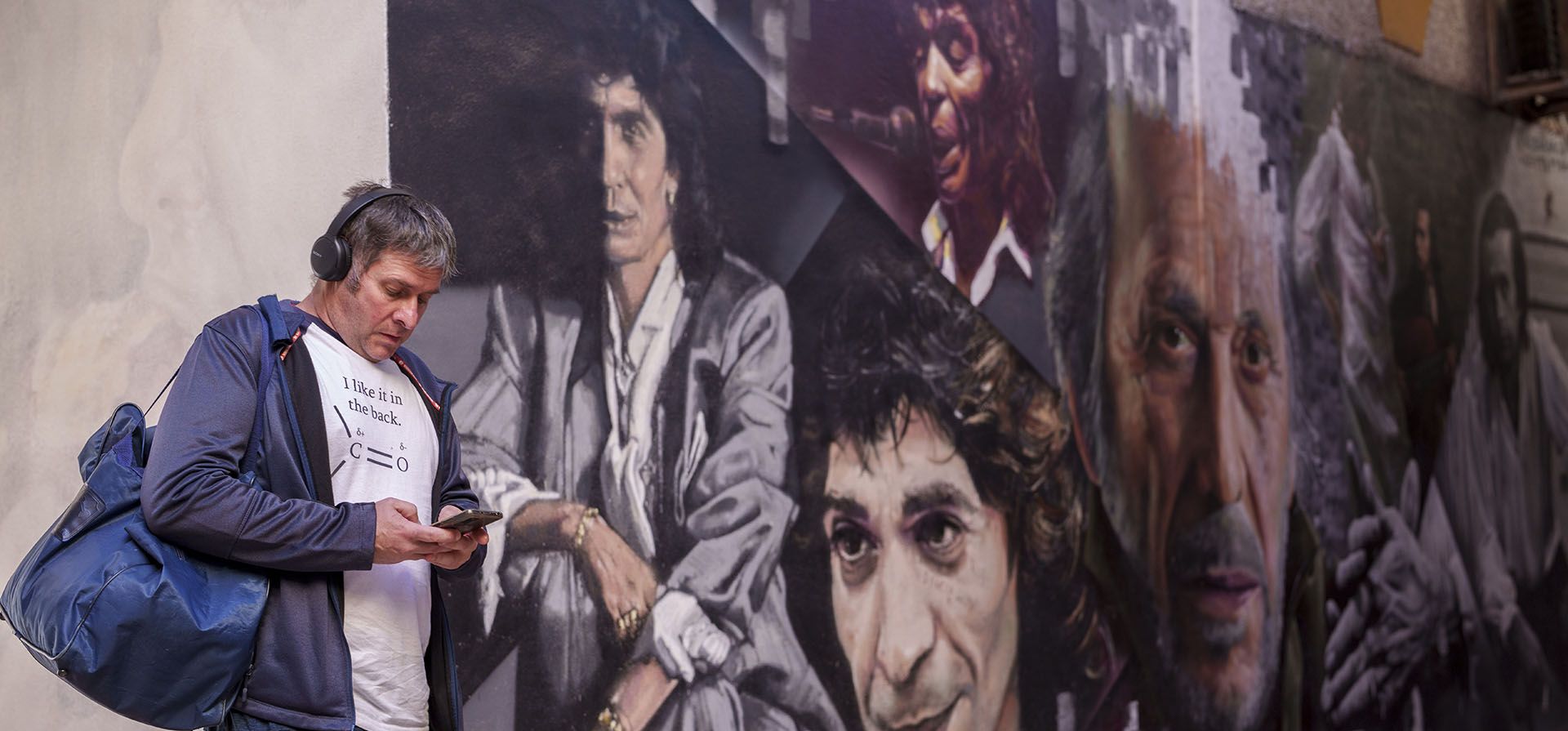 Un hombre se para frente a los graffitis de la leyenda del flamenco español "Camarón de La Isla", a la izquierda, y del fallecido guitarrista flamenco español "Paco de Lucía" en Torremolinos, sur de España, el martes 21 de noviembre de 2023. (Foto AP/Manu Fernández )