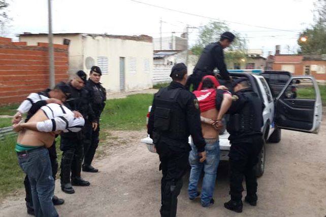 Efectivos policiales se llevan dos personas detenidas en Hipólito Irigoyen y Estrada. Foto: Juan Trento.
