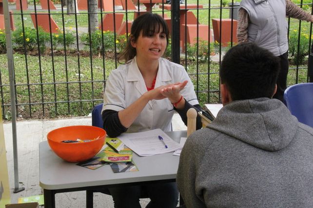 Instrucción y resultado. Una médica habla con un joven en un centro de test rápido montado en la vía pública.
