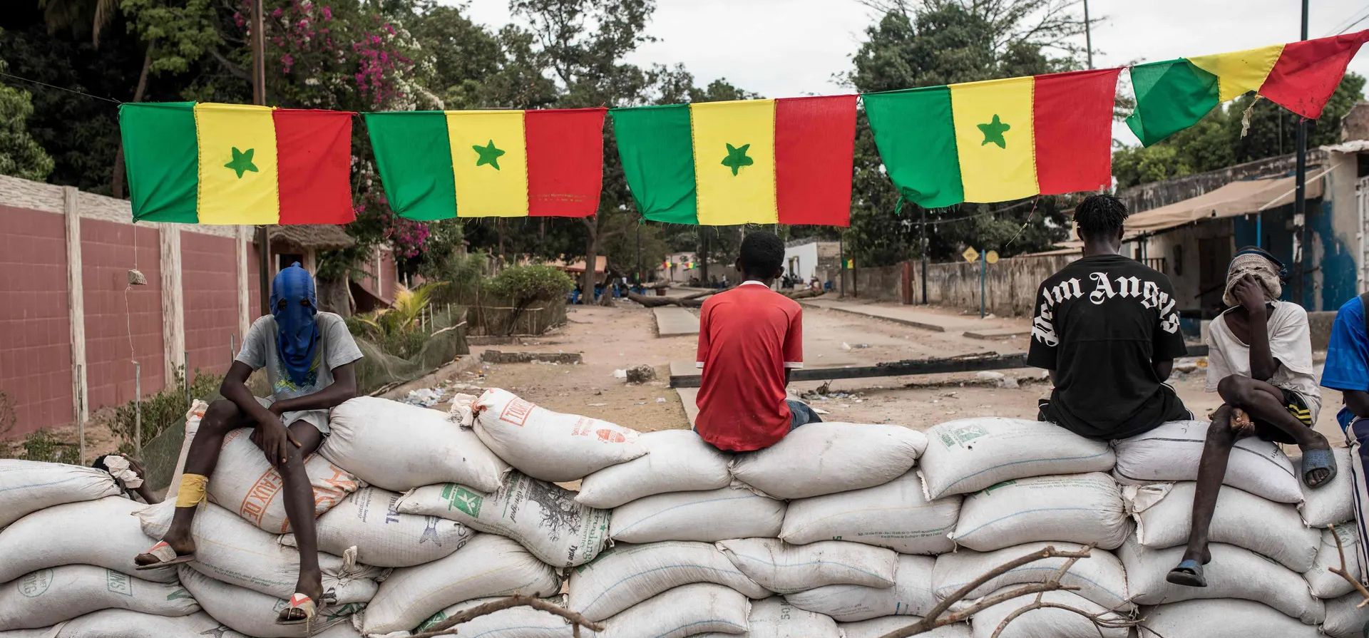 Manifestantes se sientan en barricadas de sacos de arena mientras bloquean el camino hacia la casa del líder opositor Ousmane Sonko. El hombre de 48 años está acusado de agredir sexualmente y amenazar de muerte a una mujer que trabajaba en un salón de masajes. Fotografía: Muhamadou Bittaye/AFP/Getty Images Manifestantes se sientan en barricadas de sacos de arena mientras bloquean el camino hacia la casa del líder opositor Ousmane Sonko. El hombre de 48 años está acusado de agredir sexualmente y amenazar de muerte a una mujer que trabajaba en un salón de masajes. Fotografía: Muhamadou Bittaye/AFP/Getty Images
