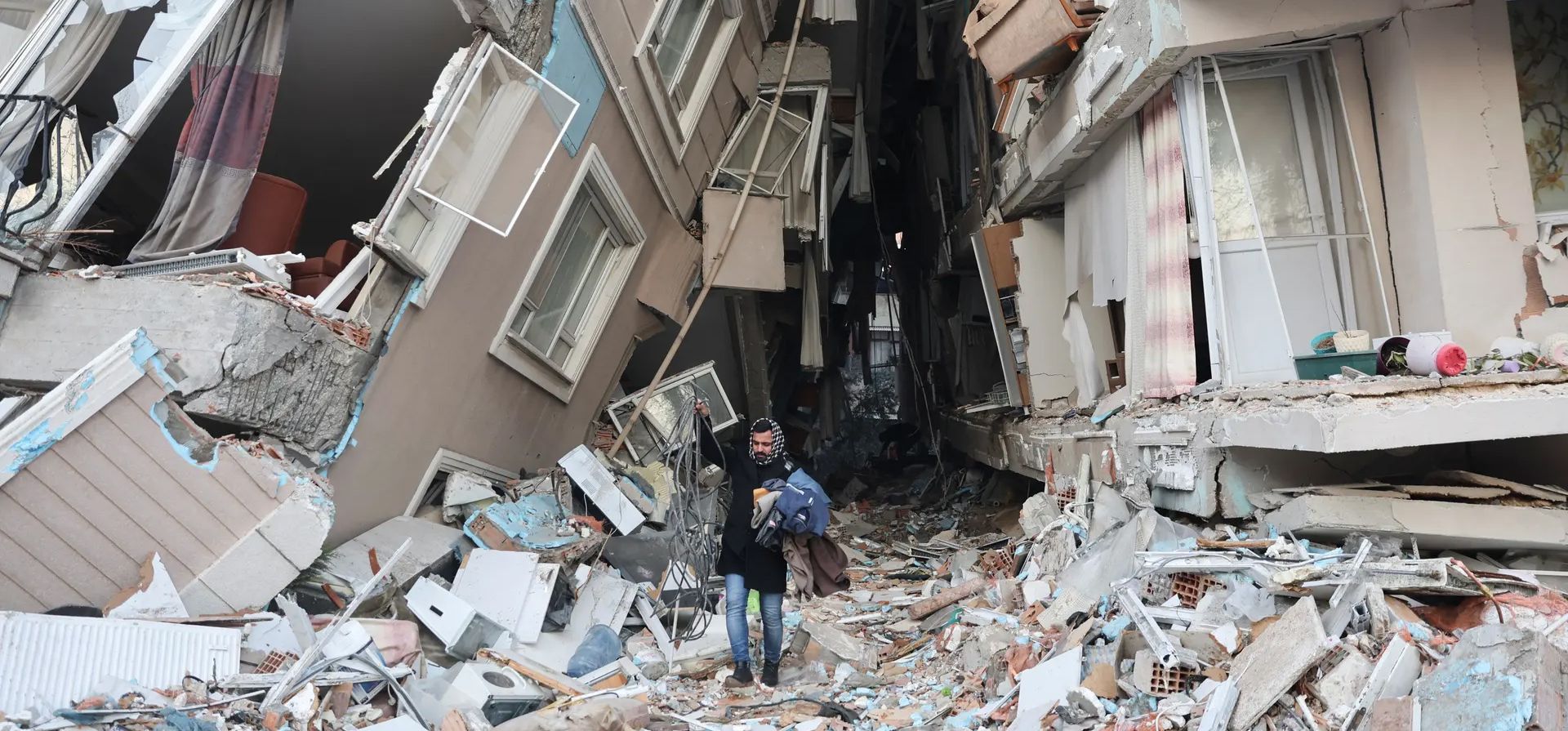 Un sobreviviente lleva pertenencias rescatadas de su casa destruida, después del mortal terremoto en Hatay,Turquía. Fotografía: Ümit Bekta/Reuters