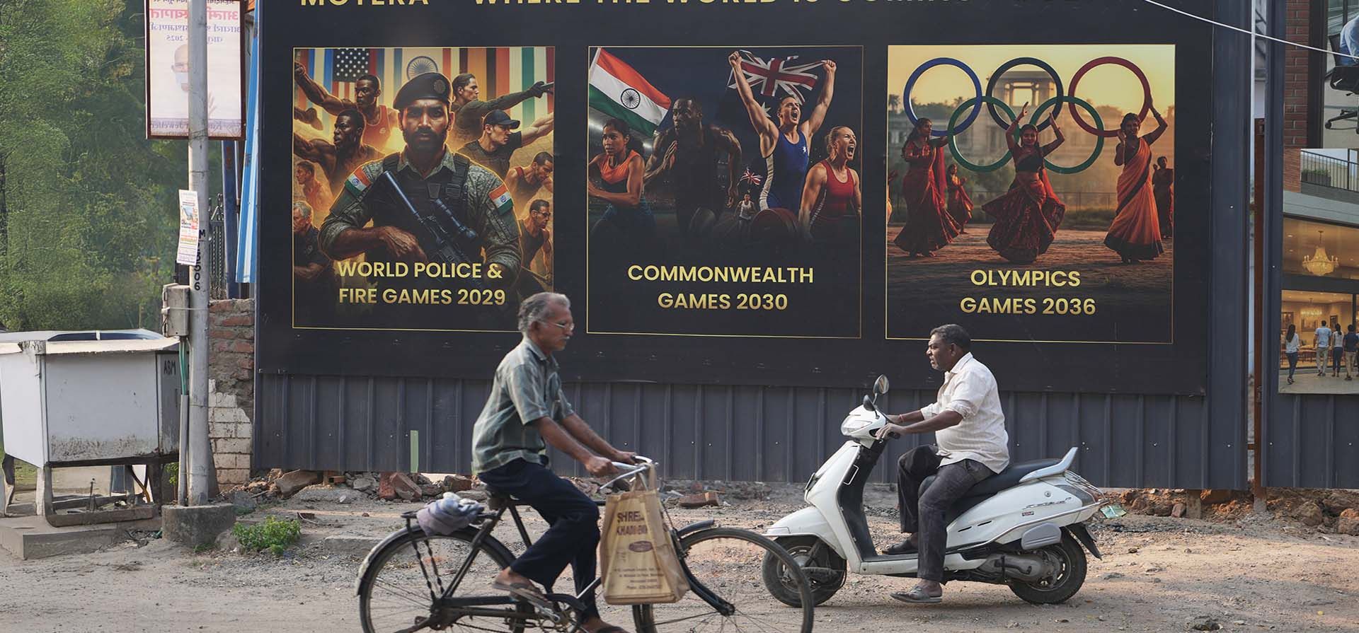 Personas pasan en bicicleta junto a carteles de proyectos residenciales que anuncian los próximos eventos deportivos, en vísperas de la Asamblea General de Deportes de la Commonwealth en Glasgow para la aprobación formal de la ciudad anfitriona, en Ahmedabad, India, el martes 25 de noviembre de 2025. (Foto AP/Ajit Solanki) Personas pasan en bicicleta junto a carteles de proyectos residenciales que anuncian los próximos eventos deportivos, en vísperas de la Asamblea General de Deportes de la Commonwealth en Glasgow para la aprobación formal de la ciudad anfitriona, en Ahmedabad, India, el martes 25 de noviembre de 2025. (Foto AP/Ajit Solanki)