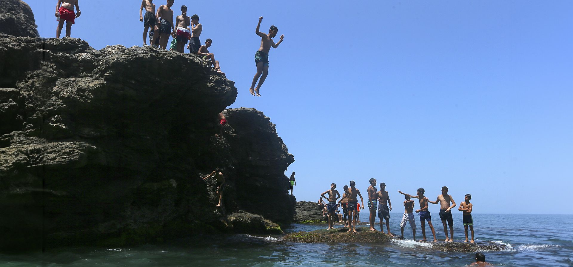 La gente salta al agua para refrescarse en un día de calor sofocante en el mar Mediterráneo en Beirut, Líbano. Se pronostica que la temperatura alcanzará los 40 grados centígrados en algunas partes del país. (Foto AP/Hassan Ammar)