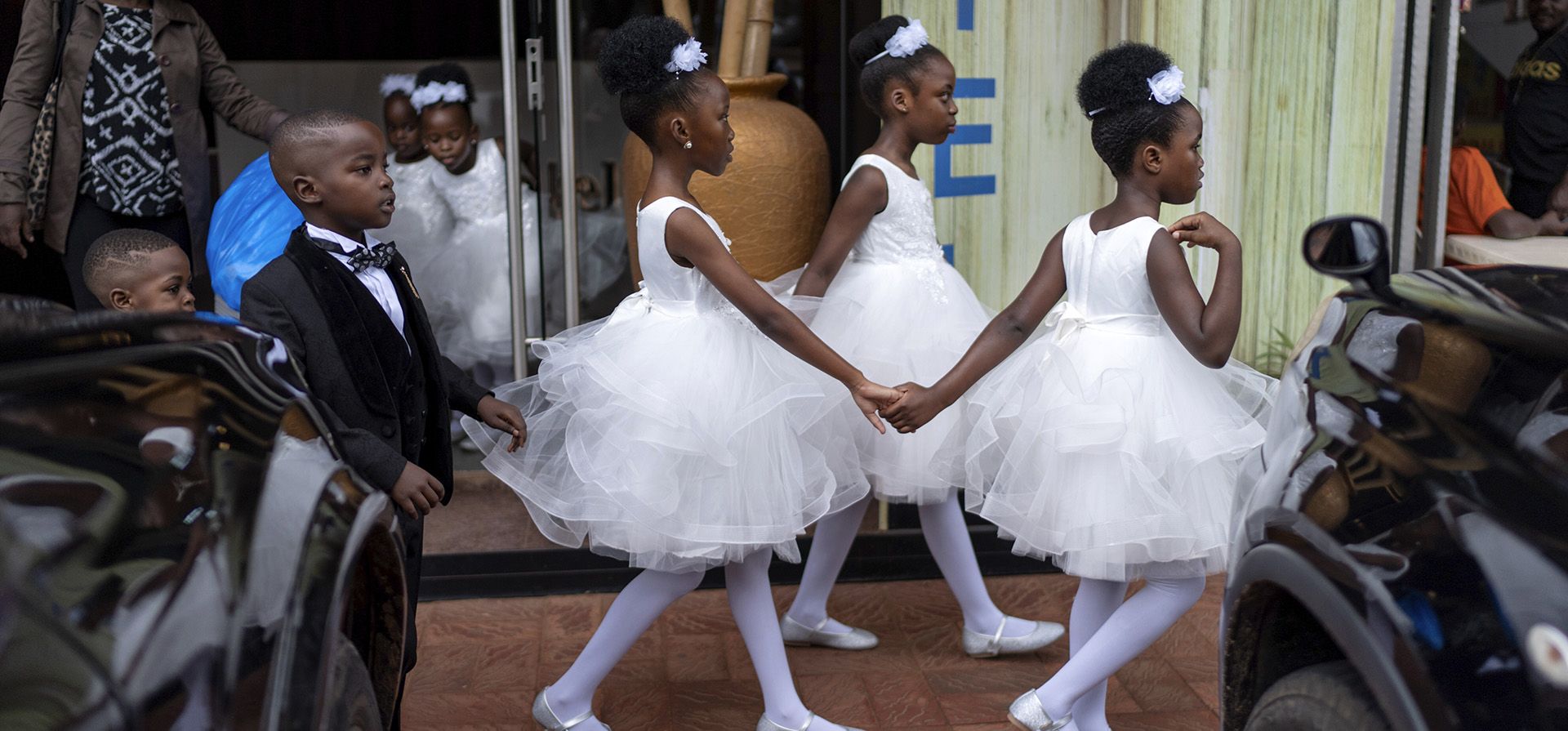 Niñas que forman parte de una fiesta nupcial se toman de la mano al salir de un hotel para asistir a la ceremonia, el sábado 23 de noviembre de 2024, en Kampala, Uganda, hogar de unos 25 millones de niños, aproximadamente la mitad de la población del país. (Foto AP/David Goldman) Niñas que forman parte de una fiesta nupcial se toman de la mano al salir de un hotel para asistir a la ceremonia, el sábado 23 de noviembre de 2024, en Kampala, Uganda, hogar de unos 25 millones de niños, aproximadamente la mitad de la población del país. (Foto AP/David Goldman)
