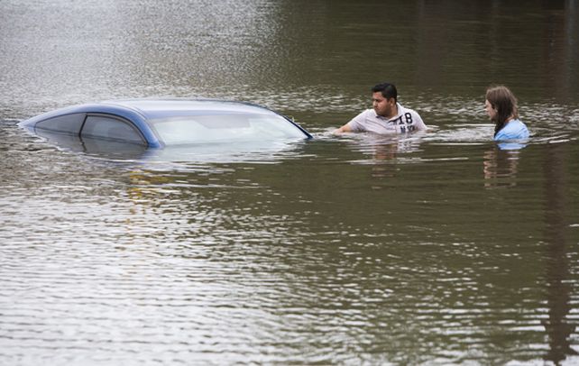 Houston. Una pareja estadounidense flota en el agua junto a un auto