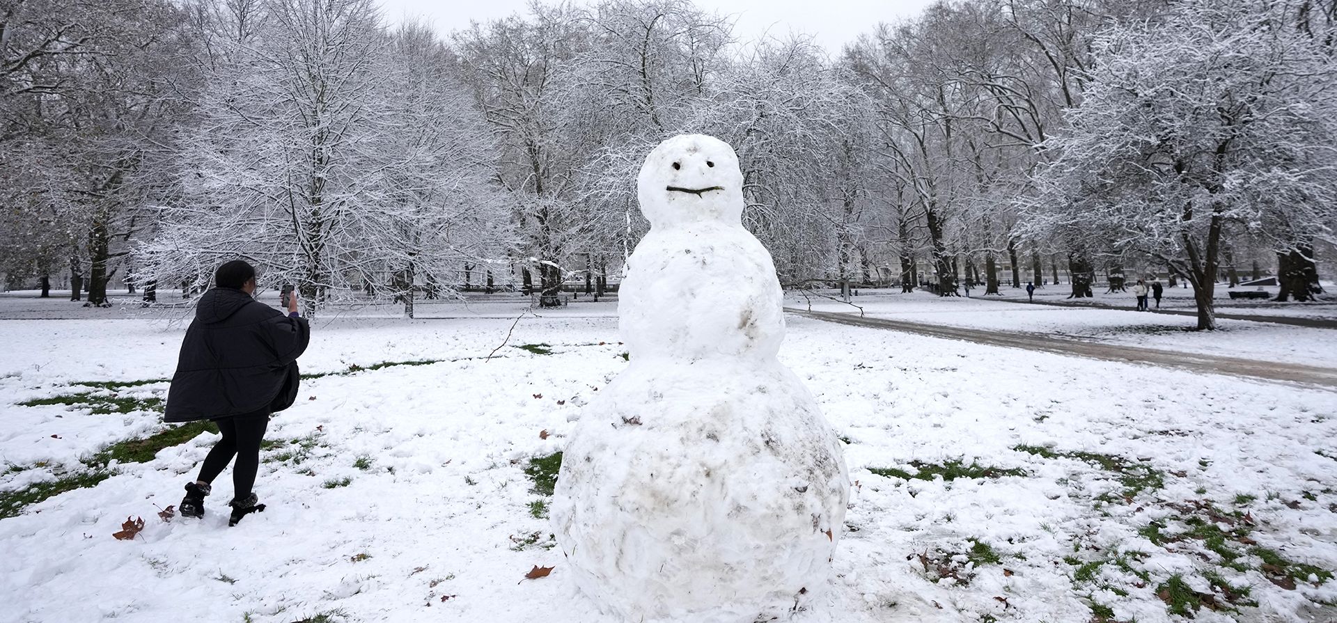 Una mujer fotografía un muñeco de nieve en Green Park en Londres, el lunes 12 de diciembre de 2022. (Foto AP/Kirsty Wigglesworth)