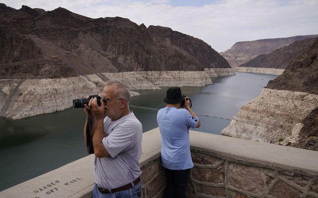 Gente toma fotografías del lago Mead cerca de la presa Hoover en el Área Recreativa Nacional del Lago Mead