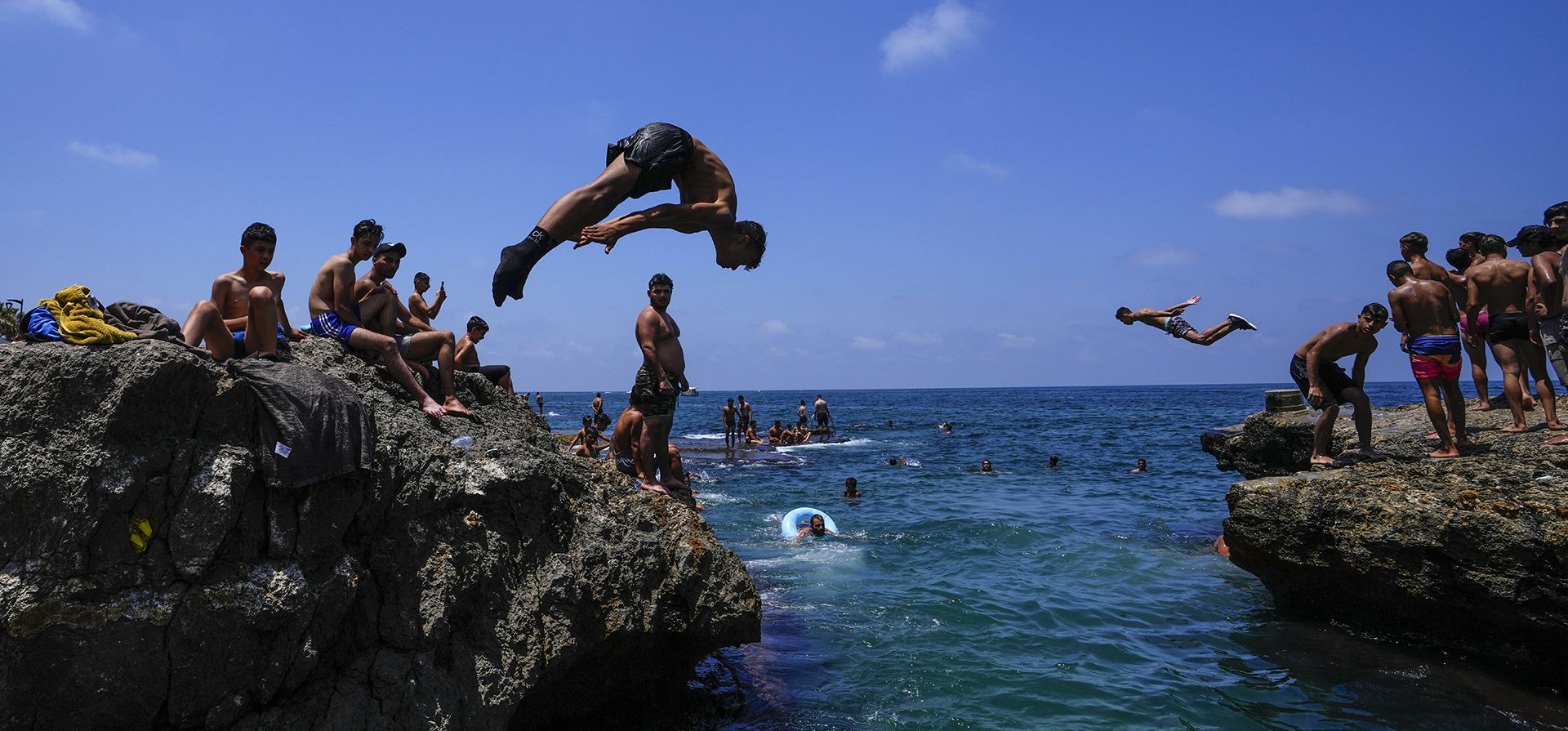 La gente salta al agua para refrescarse en un día de calor sofocante en el mar Mediterráneo en Beirut, Líbano. Se pronostica que la temperatura alcanzará los 40 grados centígrados en algunas partes del país. (Foto AP/Hassan Ammar)