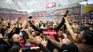 Jeremie Frimpong celebra junto a una multitud de hinchas en el campo de juego el campeonato del Bayer Leverkusen en la Bundesliga.