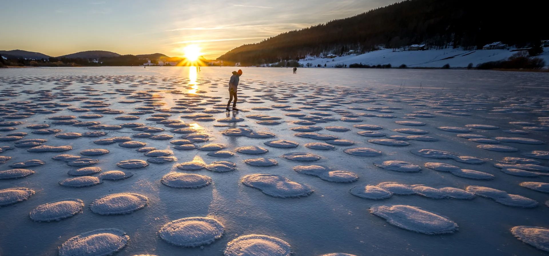 Un patinador observa el hielo de panqueques en el congelado Lac des Rousses, en el este de Francia. Este fenómeno se forma cuando el hielo fangoso en el agua se agrupa en formas redondas parecidas a panqueques debido a las olas o las corrientes, Les Rousses, Francia. Fotografía: Fabrice Coffrini/AFP/Getty Images Un patinador observa el hielo de panqueques en el congelado Lac des Rousses, en el este de Francia. Este fenómeno se forma cuando el hielo fangoso en el agua se agrupa en formas redondas parecidas a panqueques debido a las olas o las corrientes, Les Rousses, Francia. Fotografía: Fabrice Coffrini/AFP/Getty Images
