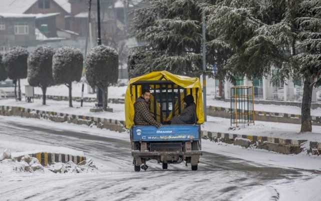 Un vehículo motorizado transita sobre las heladas calles del valle de Cachemira, la ola de frío intenso que azota la región complica la movilidad en las calles.