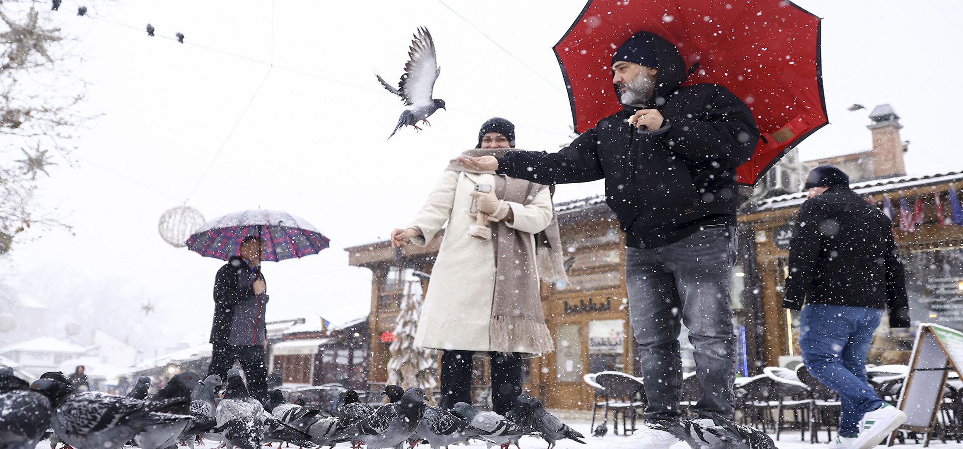 Turistas alimentan palomas durante una fuerte nevada en el centro de Sarajevo, Bosnia, el lunes 23 de diciembre de 2024. (Foto AP/Armin Durgut) Turistas alimentan palomas durante una fuerte nevada en el centro de Sarajevo, Bosnia, el lunes 23 de diciembre de 2024. (Foto AP/Armin Durgut)