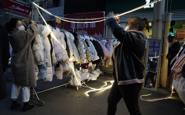 Vendedores ambulantes preparan su negocio en un mercado nocturno en Wuhan