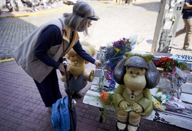 Una mujer deja flores en la escultura de Mafalda
