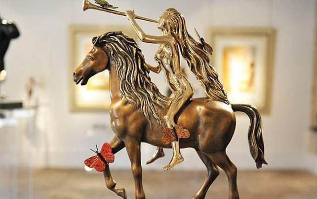 Distintiva. Lady Godiva desnuda en su caballo rodeada de mariposas.