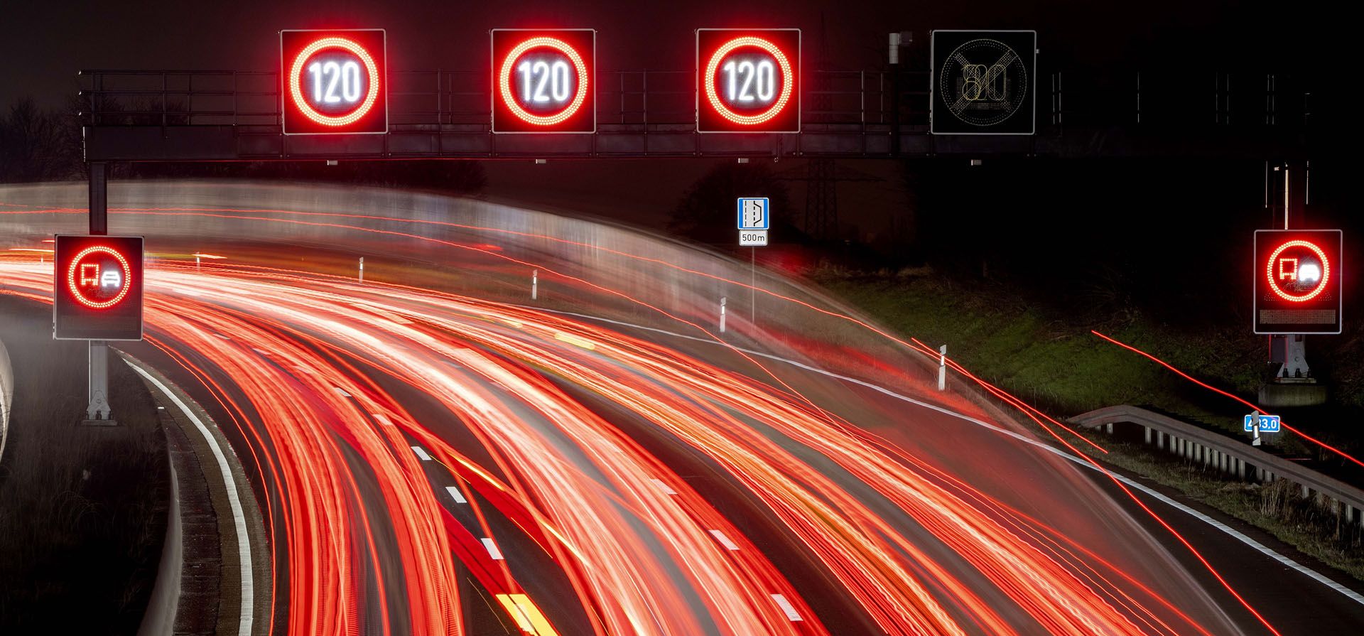 Una foto de larga exposición muestra el tráfico pasando señales de límite de velocidad en una carretera de Alemania.
