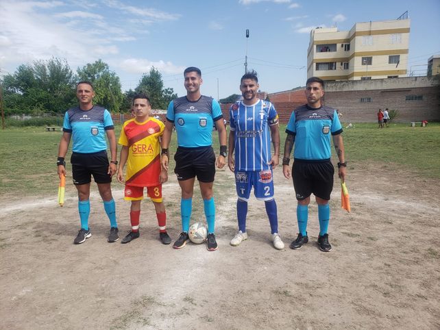 La foto de la previa. La terna arbitral y los capitanes  de 1º de Mayo y Jorgito. El partido se disputó en el histórica cancha de Sparta.    