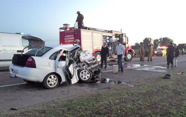 Violento. Bomberos voluntarios y policías despejan la ruta de los despojos del taxi