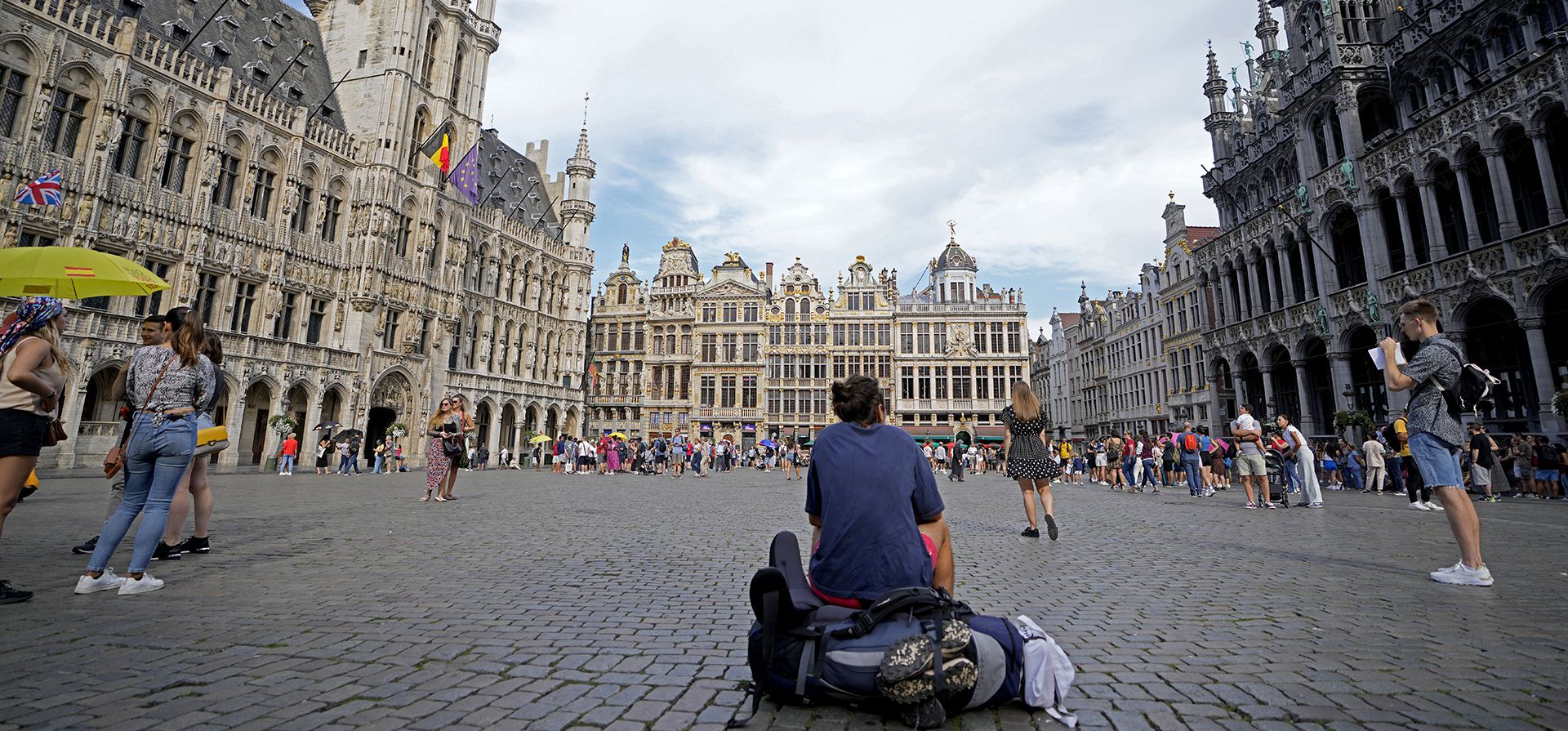 Un hombre se sienta con su mochila en el centro de la histórica Grand Place de Bruselas el miércoles, 24 de agosto de 2022.