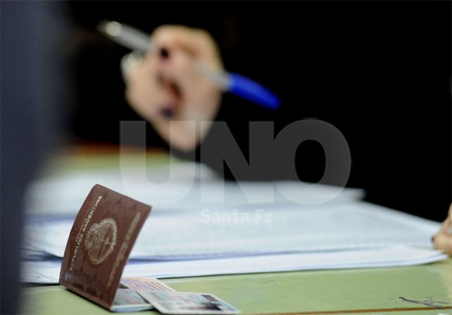Proceso. El presidente de mesa –auxiliado por el suplente– abre la urna / Foto: José Busiemi - Uno Santa Fe