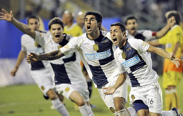 Pachi Carrizo sale corriendo eufórico porque acaba de marcar el gol del triunfo canalla. Detrás aparece Toledo