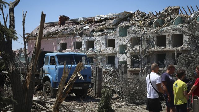 Los residentes locales observan un edificio dañado en la ciudad de Serhiivka